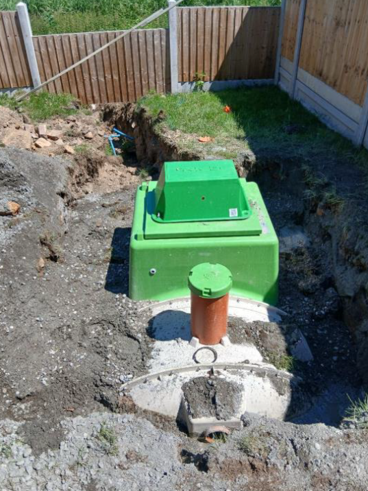 Tricel Novo UK6 sewage treatment plant positioned in rear garden excavation